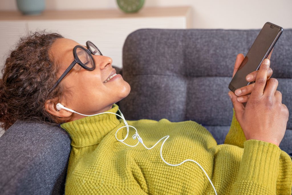 Woman lying on couch with headphones in