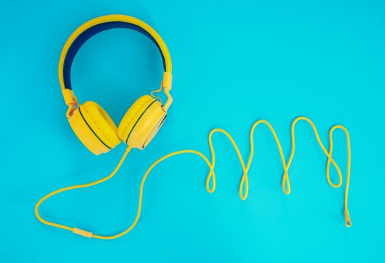 Yellow over-ear headphones on bright blue background