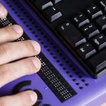 Blind person using computer with braille computer display