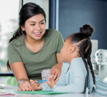 female teaching working with young student