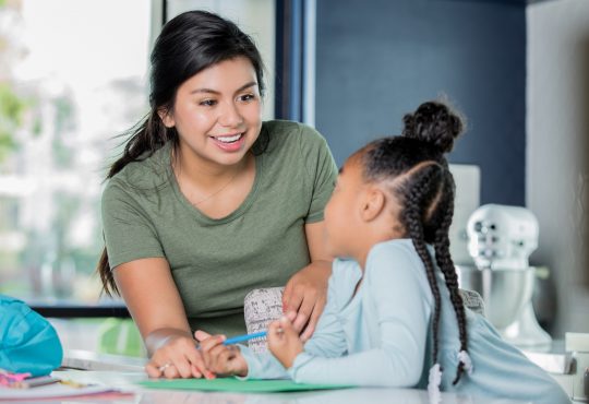 female teaching working with young student