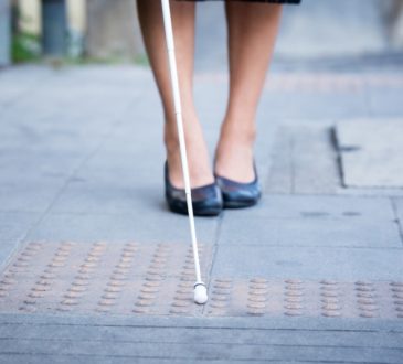 woman walking with white support cane