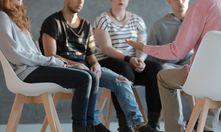 people sitting in chairs for group counselling session