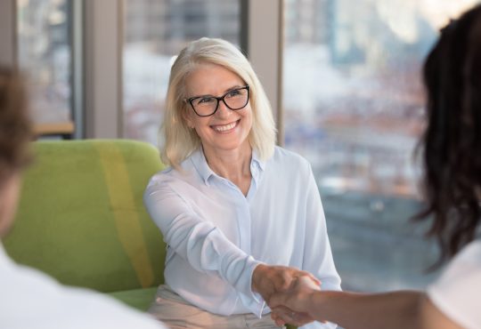 two women shake hands during job interview