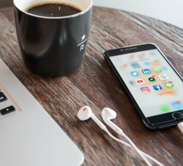 Phone on table beside laptop and coffee mug