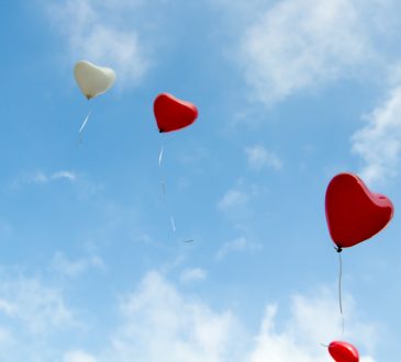 heart-shaped balloons floating in the sky