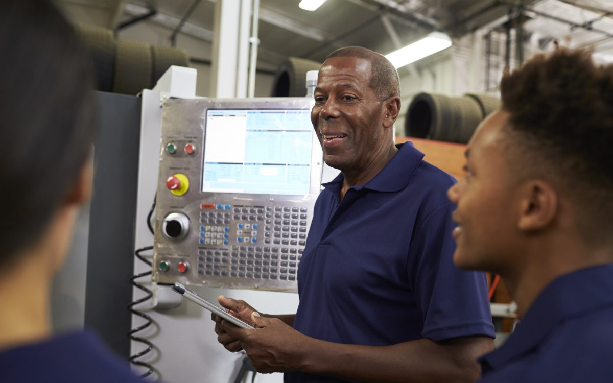 Engineer Training Apprentices On CNC Machine