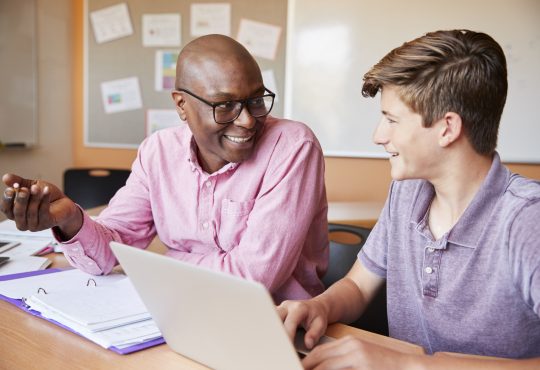 male teacher talking with male high school student