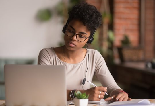 woman wearing headphones watching webinar