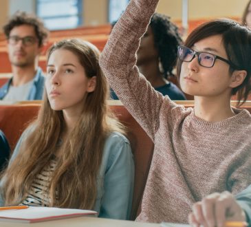 student raising hand in lecture