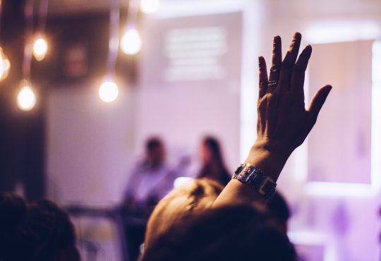 person in audience raising hand