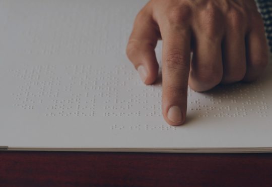 close up of hand of person reading braille