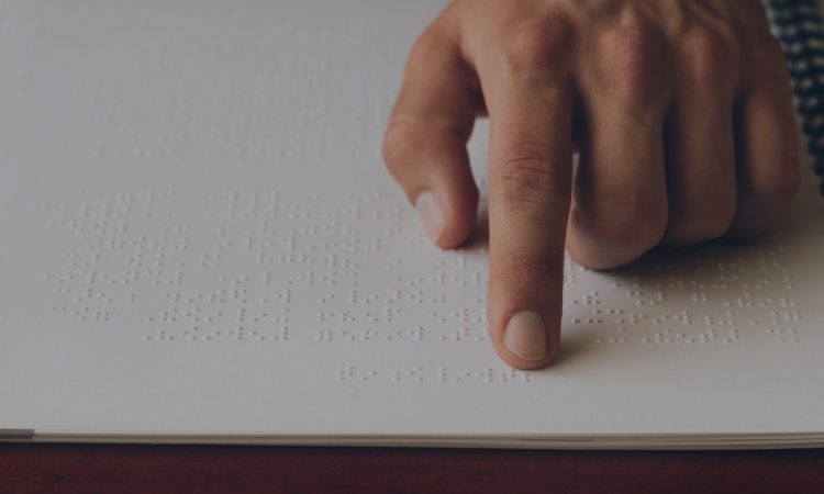 close up of hand of person reading braille