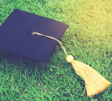 shot of graduation hats on the grass