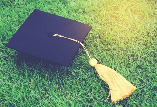 shot of graduation hats on the grass