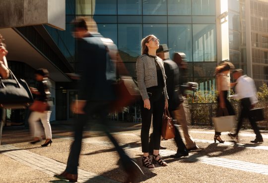 Woman standing amidst a busy office-going crowd