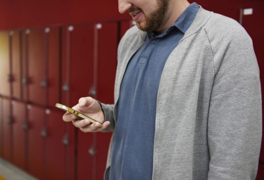 man looking down at cellphone in hand