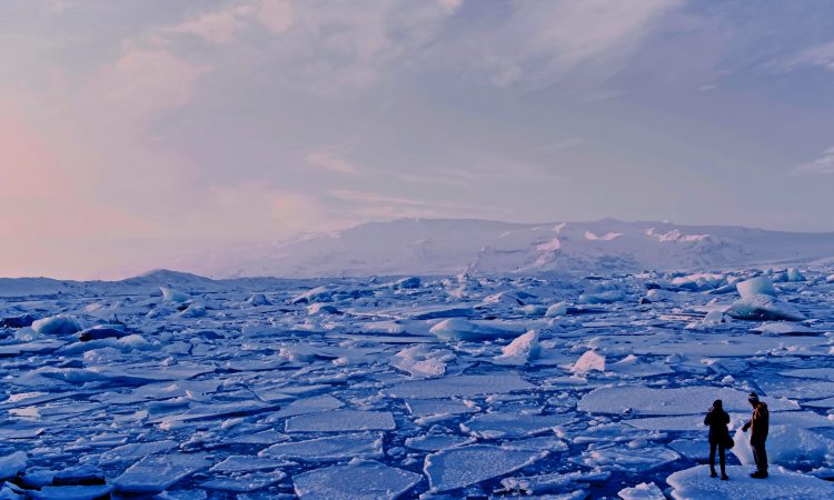 man and woman standing on broken ice in arctic