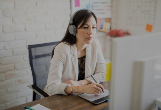 woman wearing headphones while working at desk