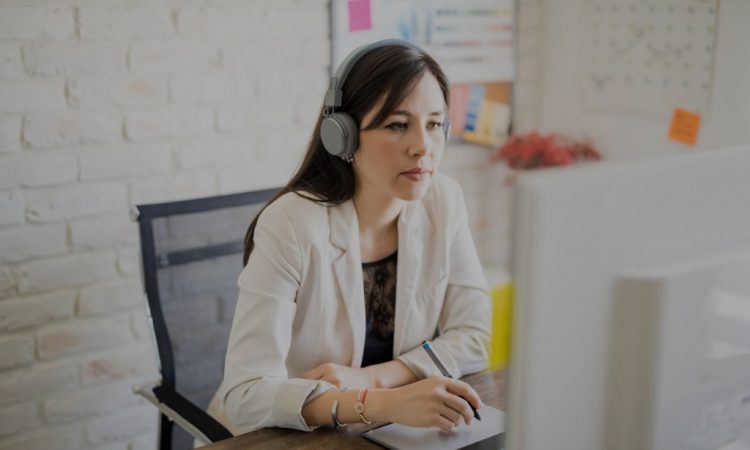 woman wearing headphones while working at desk