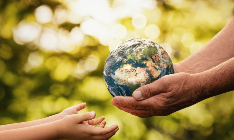 Close up of senior hands giving small planet earth to a child