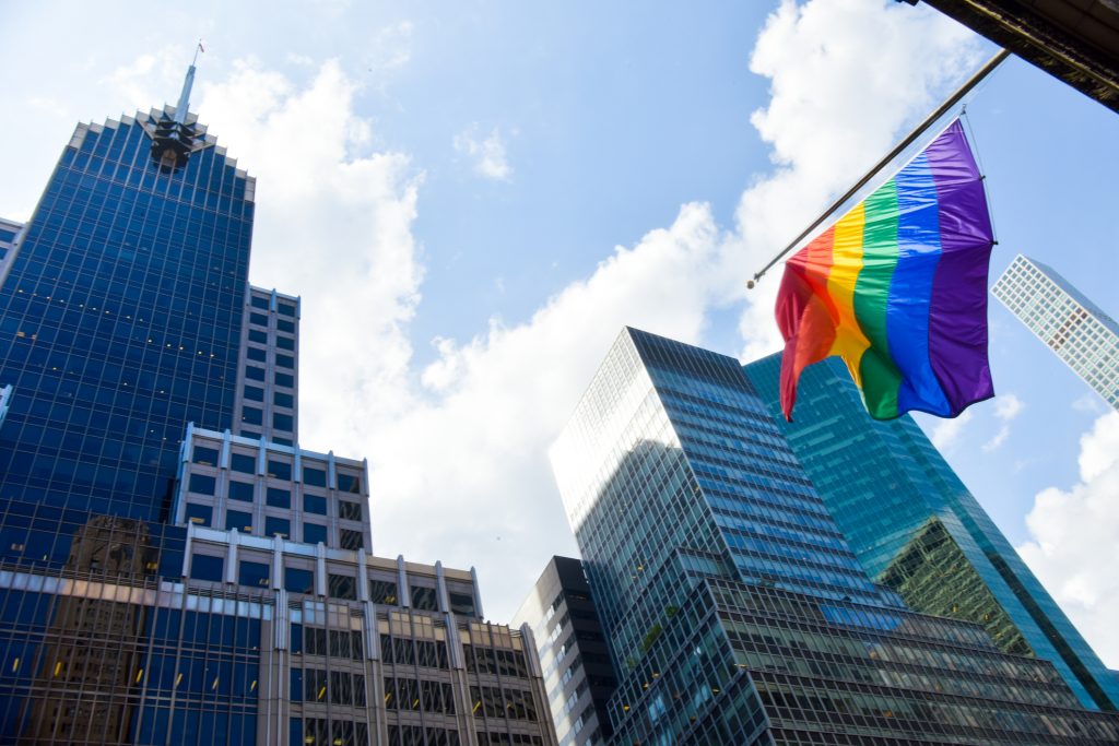 A street level shot of a pride flag and corporate buildings in midtown Manhattan, New York City