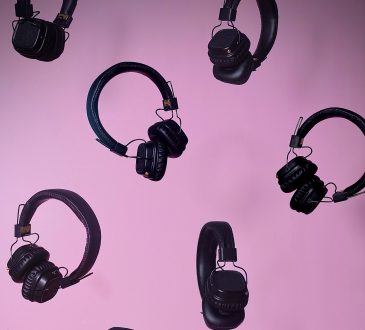 multiple pairs of over ear headphones floating on purple background