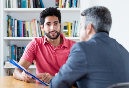 two men talking in office