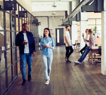 man and woman walking in open-concept office