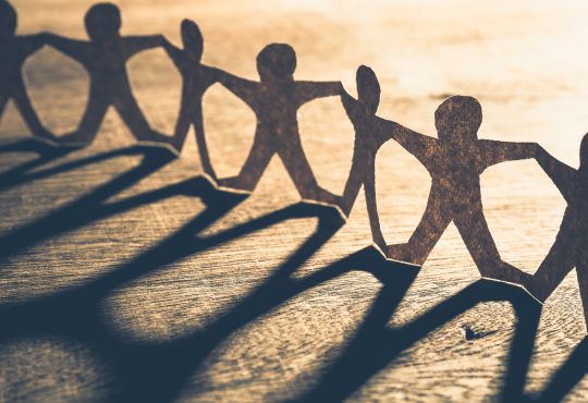 Human chain made from paper on wood table