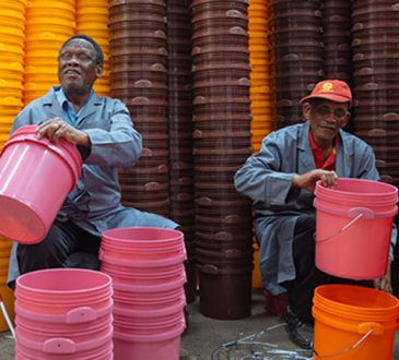 two men stacking buckets