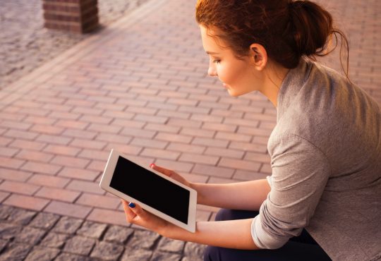 woman looking at tablet