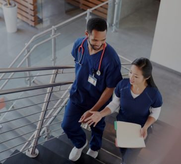 male and female nurse walking up hospital stairs