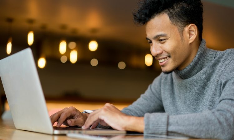 happy man typing on laptop