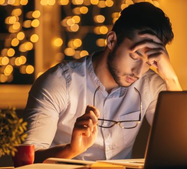 frustrated man with eyes closed in front of computer