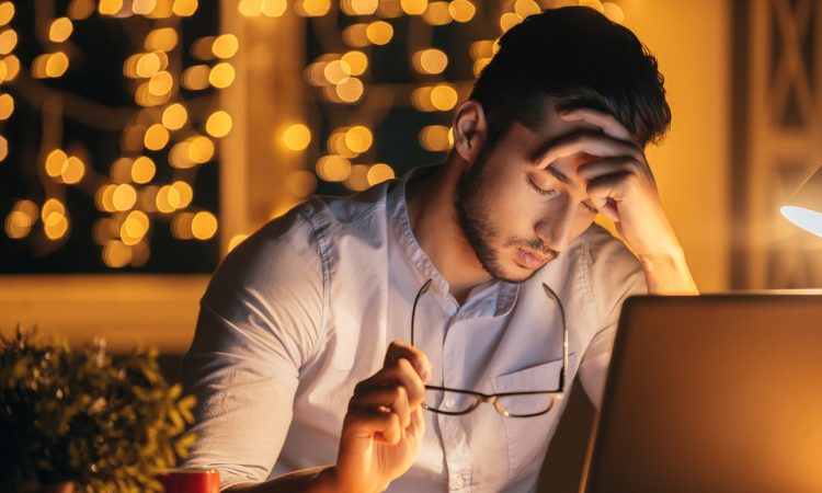 frustrated man with eyes closed in front of computer
