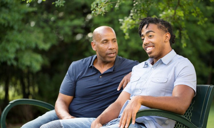 dad talking to son on park bench