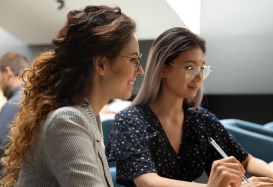 two women working together in office