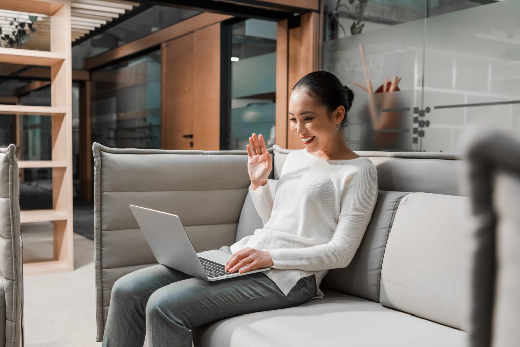 woman sitting on couch having video call