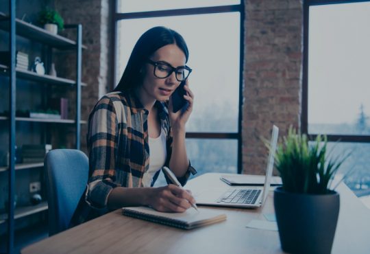 woman on phone taking notes