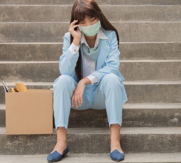 woman sits sadly on stairs after losing job