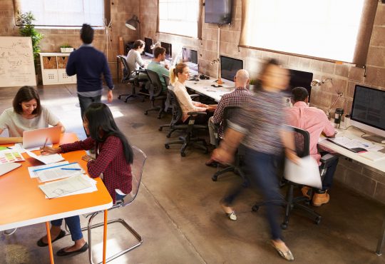 Elevated View Of Workers In Busy Modern Design Office