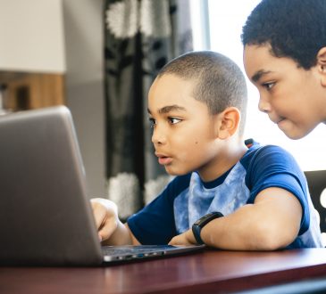 two boys using laptop