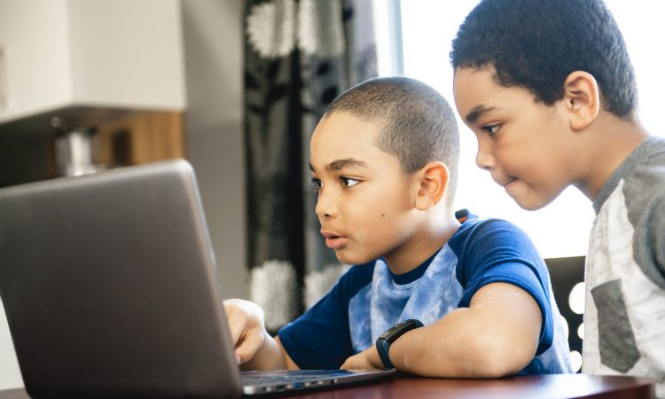 two boys using laptop