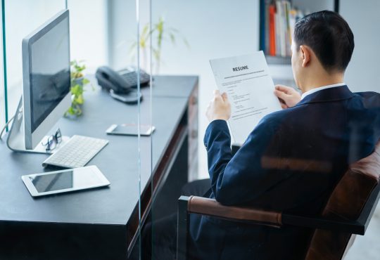 businessman reviews resume in office