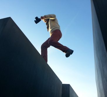 man jumping from one rooftop to another