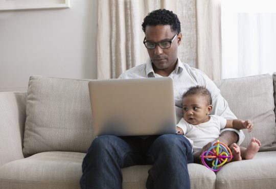 Father working from home and taking care of baby