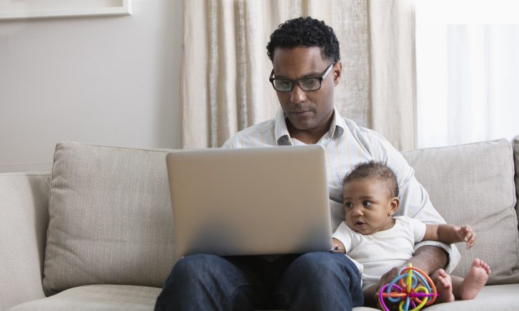 Father working from home and taking care of baby