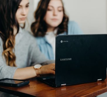 two women working together on laptop