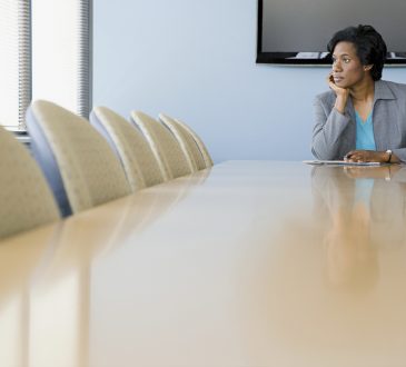 woman sitting alone in boardroom
